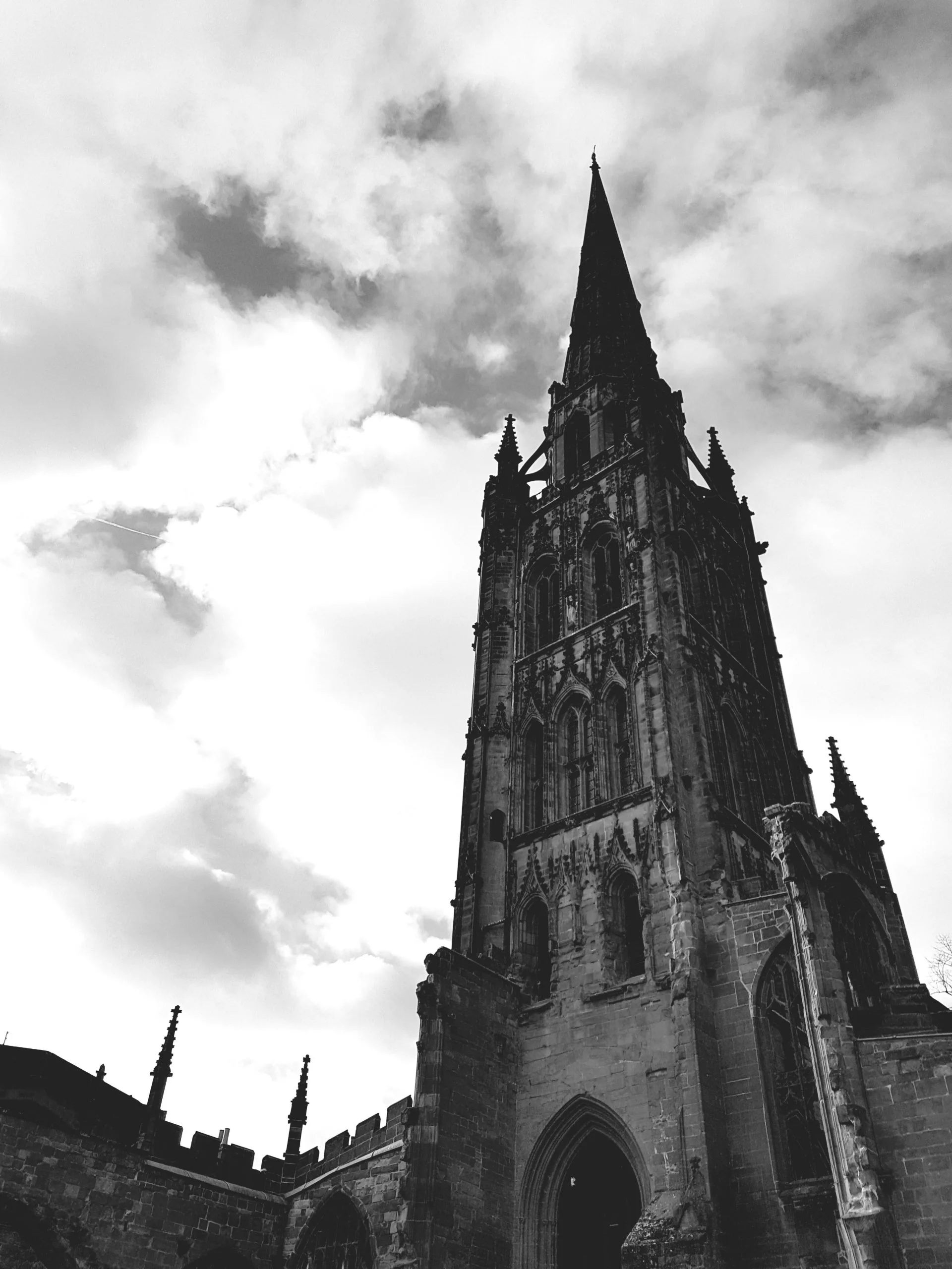A black and white photo of a cathedral tower with a quote overlaying the picture.