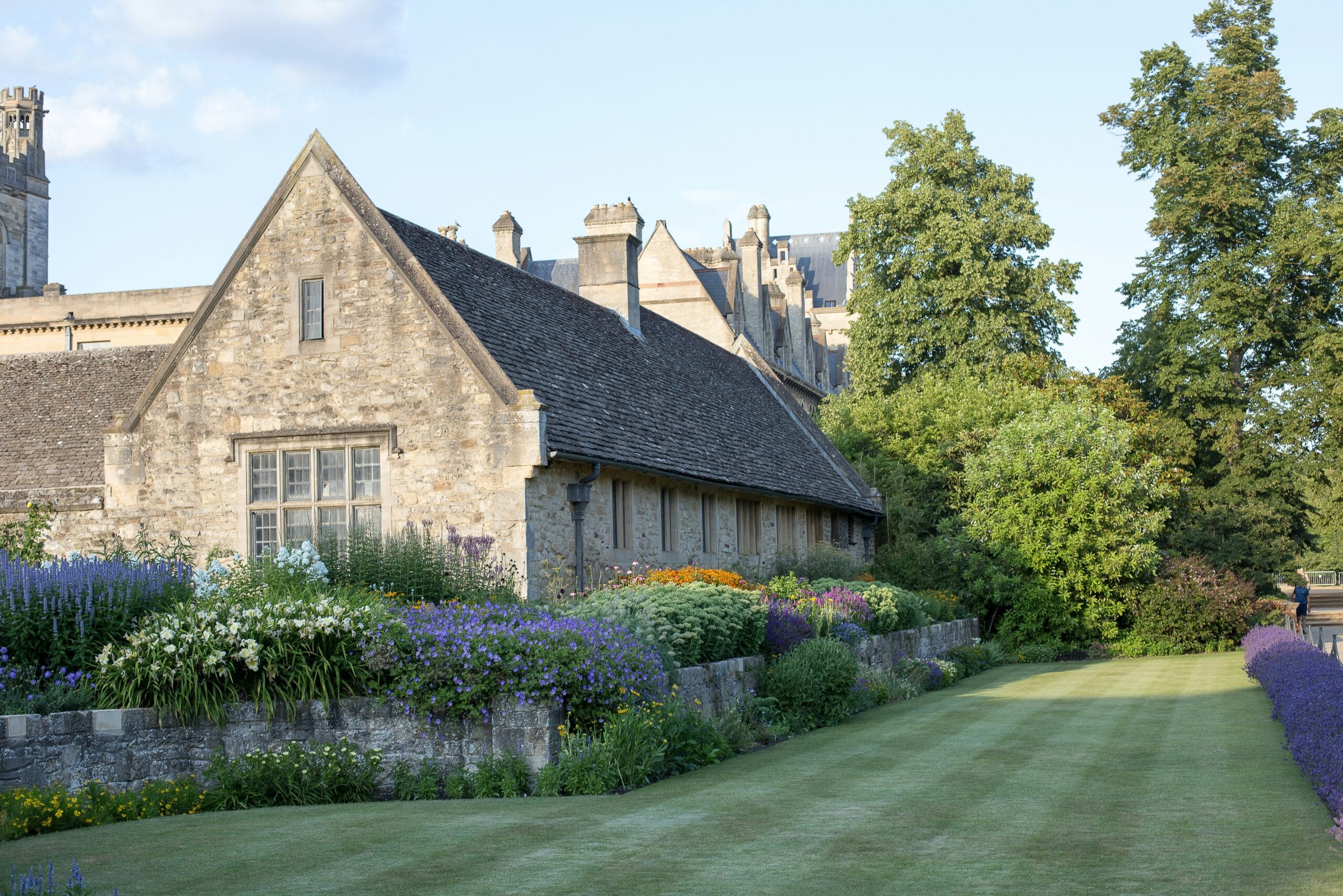 A photo of stone house and garden in the style of an English manor