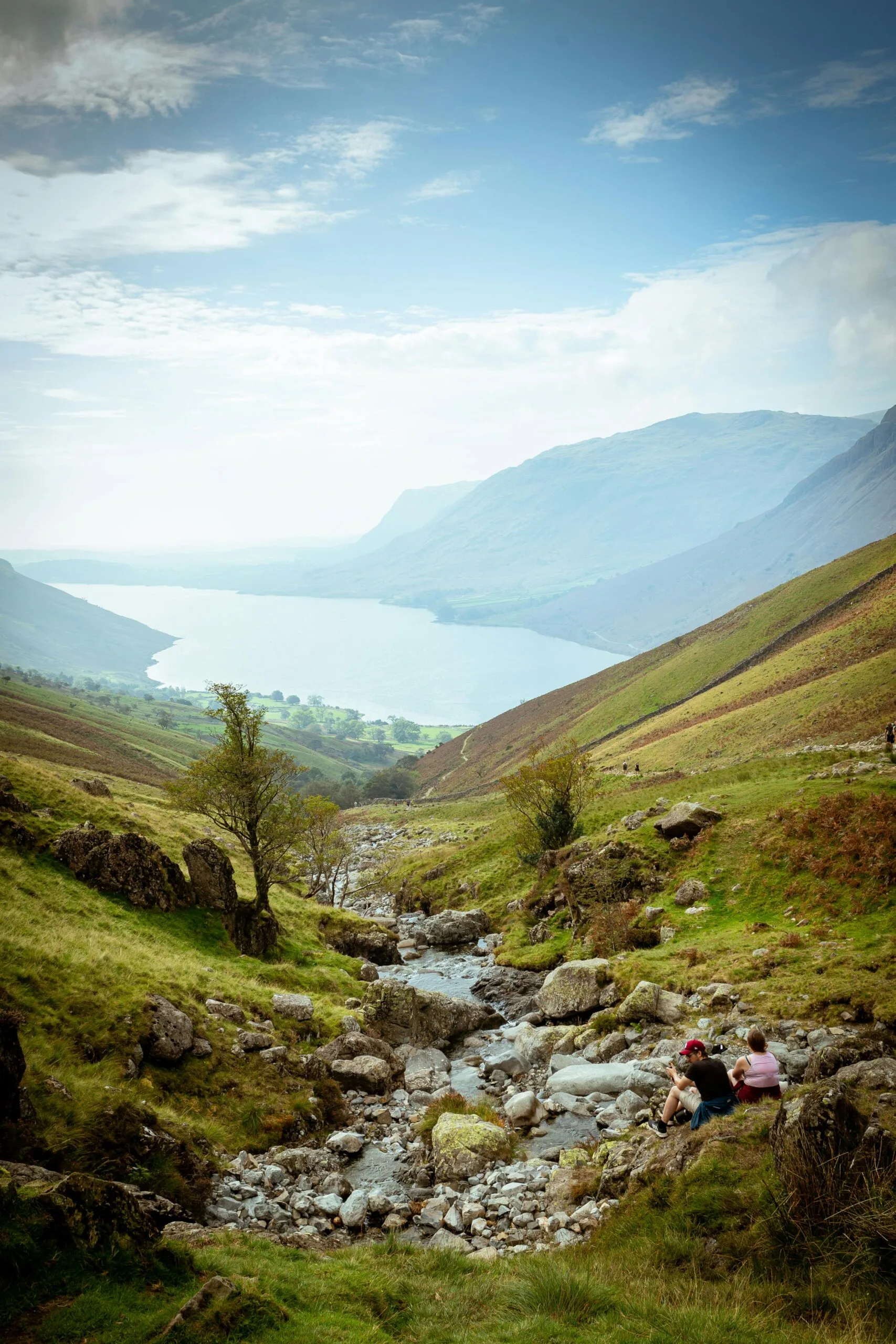 A photo of a path down to a lake surrounded by hills